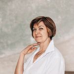 Portrait of a senior woman posing confidently in a white blouse, showcasing elegance and style.